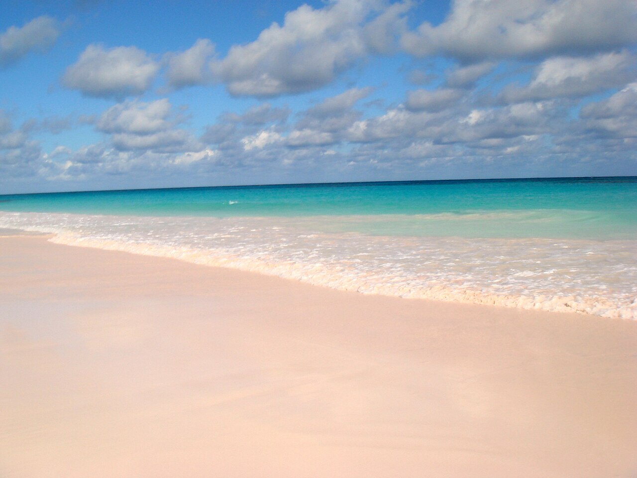 The pale pink sand of Pink Sands Beach meeting clear turquoise water on Harbour Island